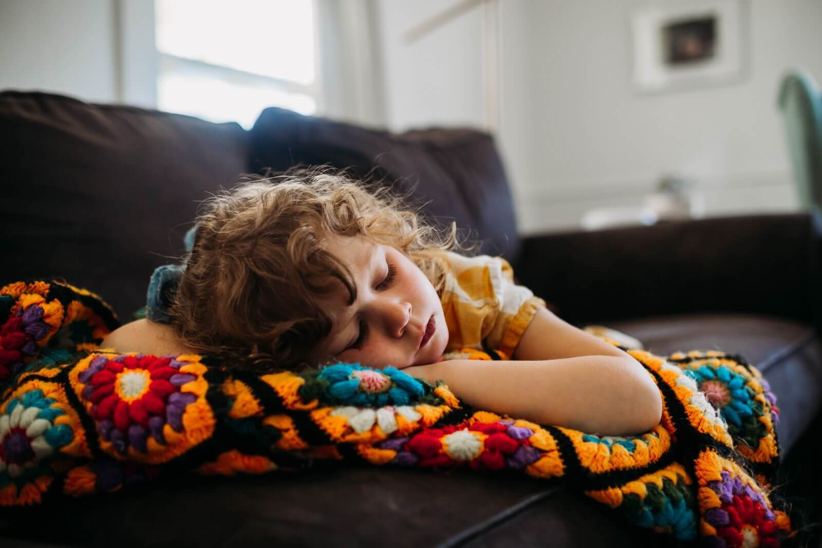 Kind liegt krank auf einer Couch